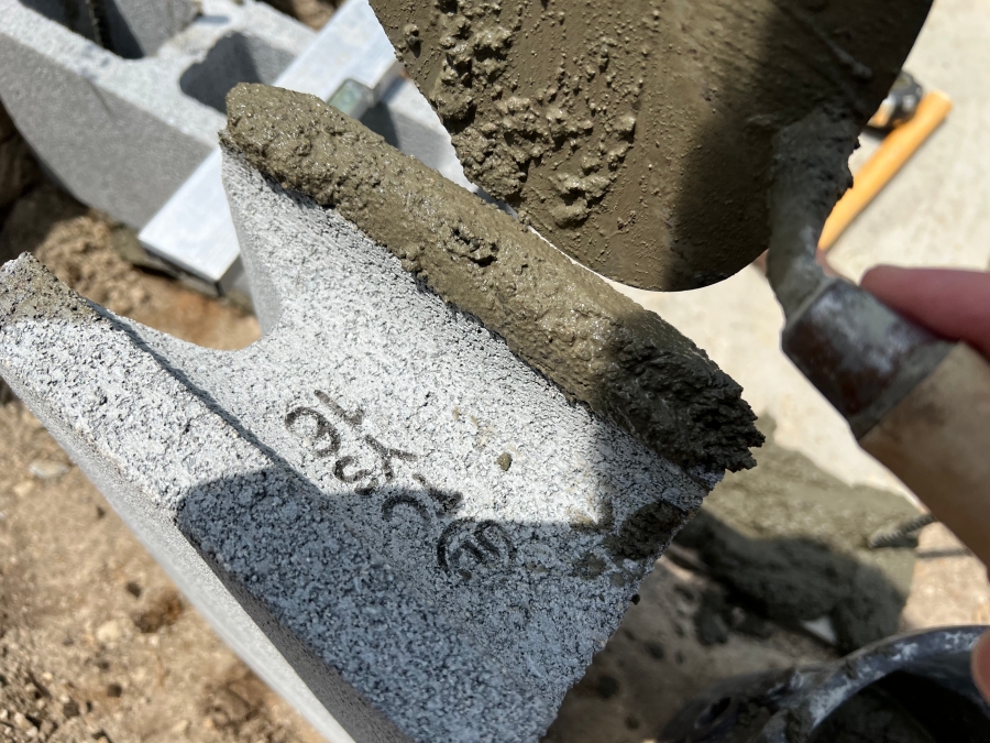 コンクリートブロックの横にモルタルを置く様子