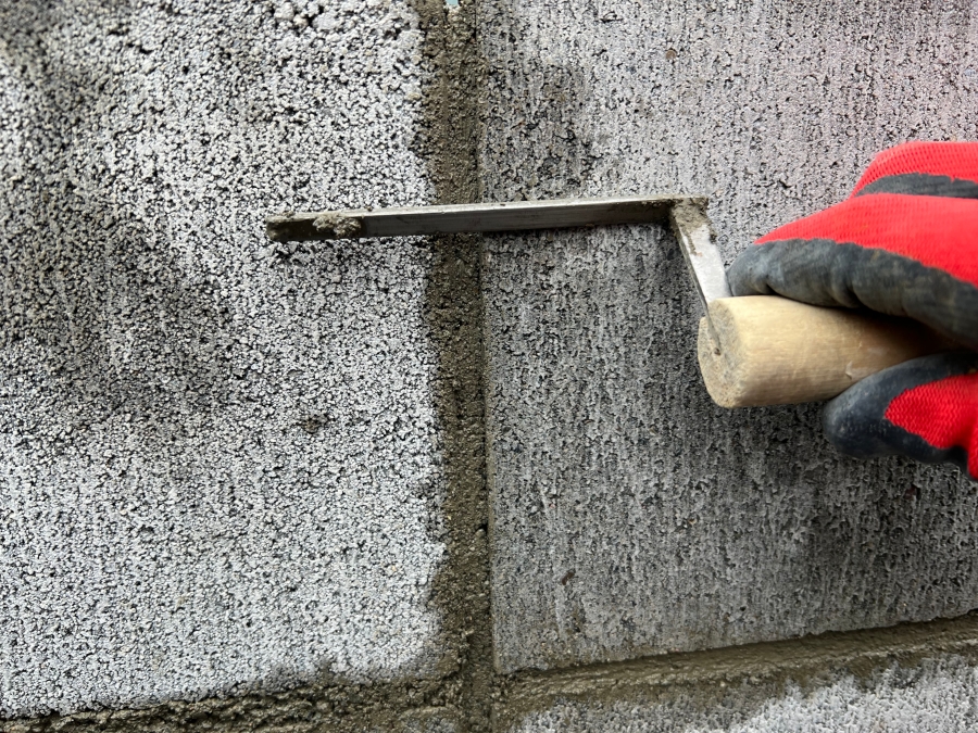 はみ出たモルタルを目地鏝で削ぎ落とす様子