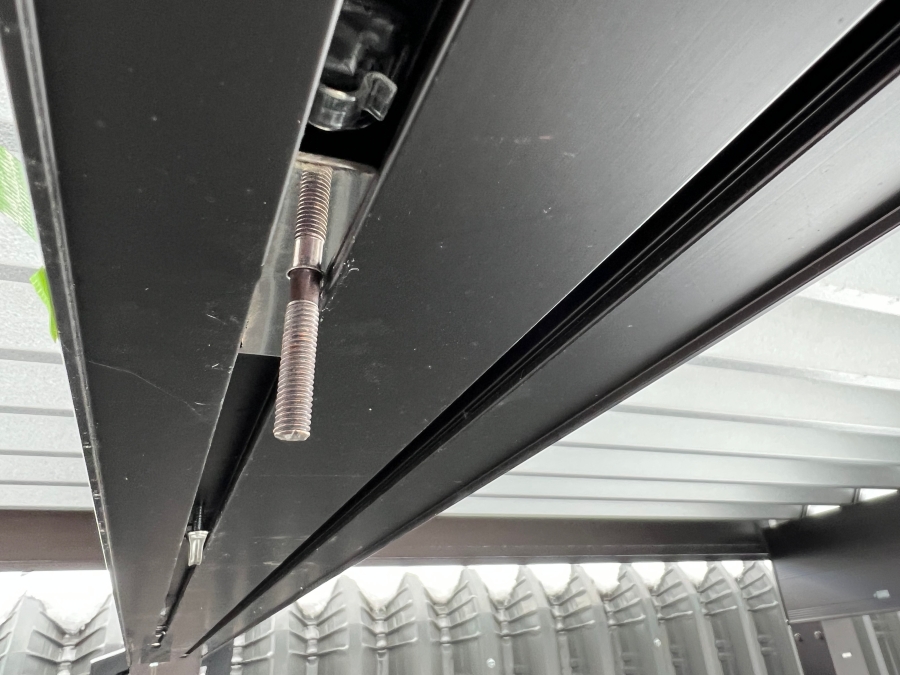 カーポート梁の溝にステンレス板を差し込む様子