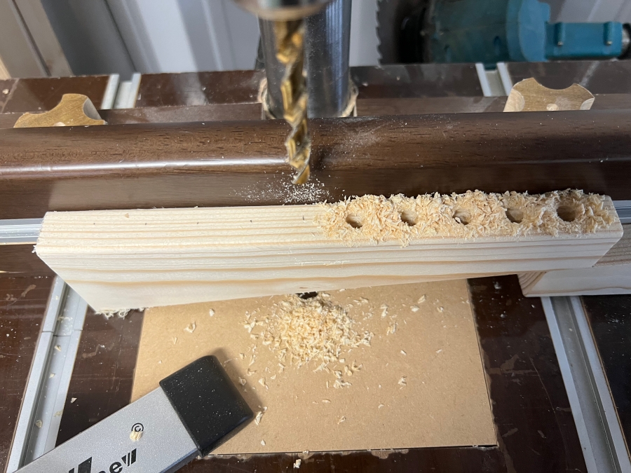 ボール盤を使ってドリルビットを収納するための穴をあける様子