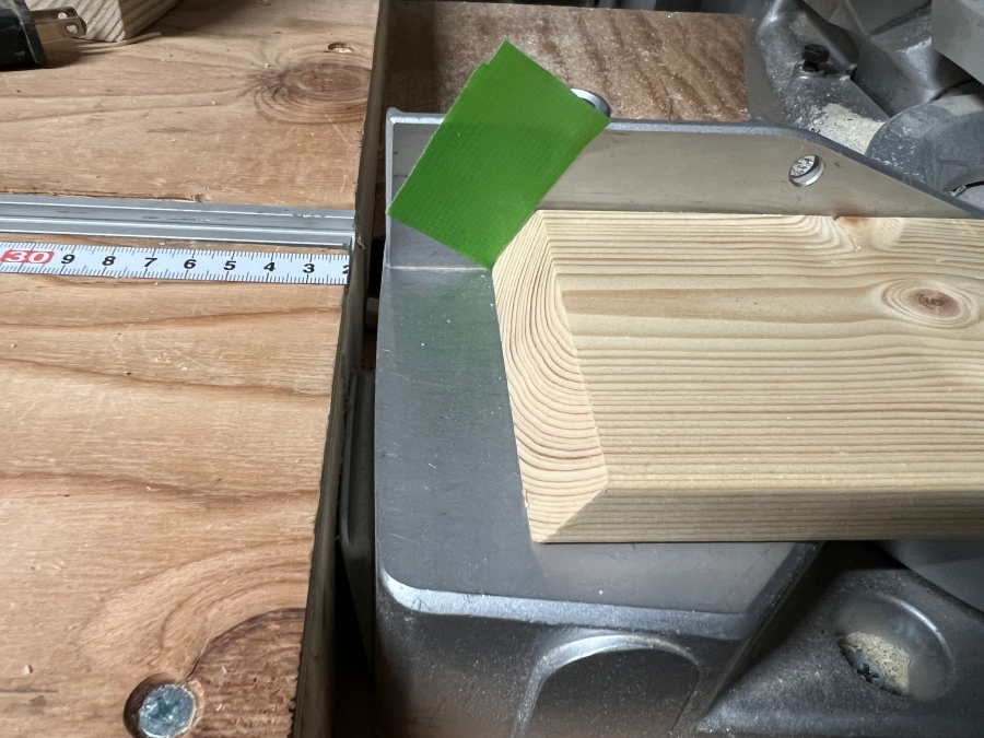 養生テープで卓上丸ノコに印をつけ、60度にカットした同サイズの木材を作る様子。