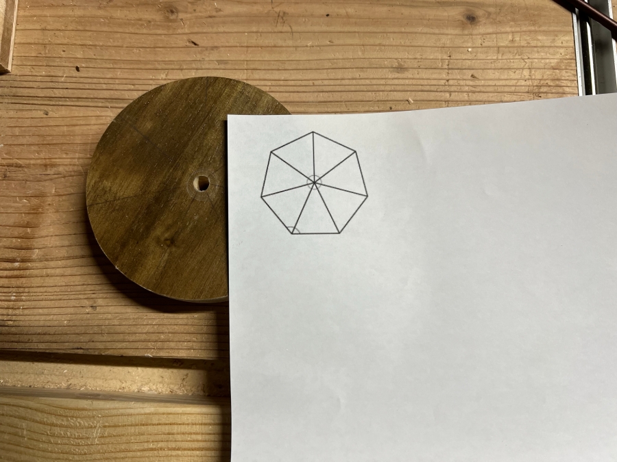 印刷した多角形の図を使って木材に印付けする様子